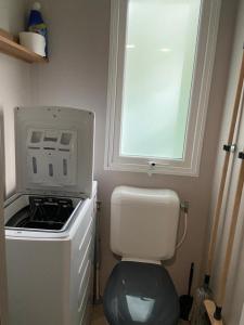 圣布里文莱丝皮恩Mobil home Aventura 6-8 personnes tout confort的一间带卫生间和窗户的小厨房