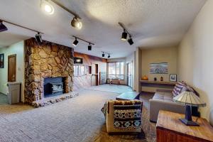 天使之火Gold Creek 206的客厅设有石制壁炉和沙发。