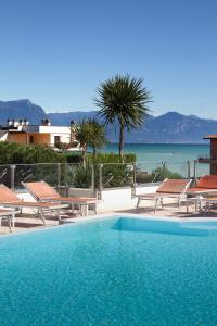 西尔米奥奈舞台酒店的一个带椅子的游泳池,享有海景