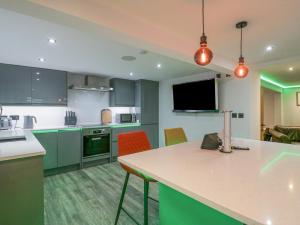 巴罗弗内斯Crag View Cottage的厨房配有绿色橱柜和桌椅
