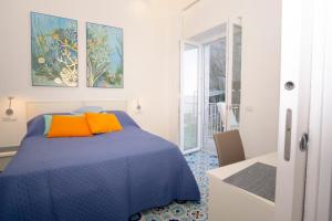 索伦托DOMUS LINA的一间卧室配有蓝色的床和橙色枕头
