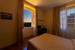 卡利亚里杜伊柯罗尼酒店的一间卧室设有一张床和一个大窗户
