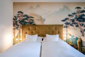 巴特维塞Boutique Hotel Relais Chalet Wilhelmy的卧室配有两张白色的床和壁画