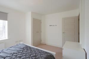 泰晤士河畔金斯顿Lovely Modern 1-Bed Flat in Kingston的一间白色卧室,配有一张床和两个衣柜