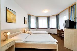 捷克克鲁姆洛夫HOTEL RAJSKY的配有2张床的带窗户和电视的客房