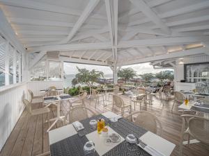 法兰西堡B&B HOTEL Fort-de-France的一间带桌椅的海景餐厅
