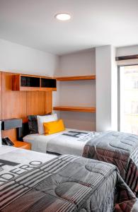拉巴斯Madero Hotel & Suites的一间卧室设有两张床和黄色枕头