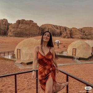 瓦迪拉姆Bubble RumCamp的站在沙漠中的穿着衣服的妇女