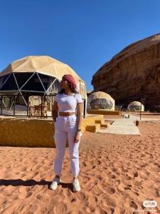 瓦迪拉姆Bubble RumCamp的站在沙漠中的沙子上的女人