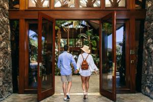 圣地亚哥卡塔马兰Spa度假酒店的走门的男人和女人