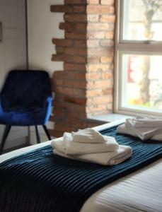 梅努斯Maynooth Serviced Studios的一张带两条白色毛巾和蓝色椅子的床