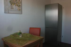 施万高Ferienwohnung Alpenrose的客房设有桌子、椅子和冰箱。