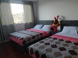 阿亚库乔HOSPEDAJE EL ARCO的一间卧室设有两张床和窗户。