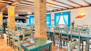 圣阿纳阿雷西La Perla Hotel的一间在房间内配有蓝色桌椅的餐厅