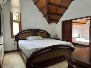 布卡拉曼加Casa Chalet en Lagos del Cacique的一间卧室配有一张大床和镜子