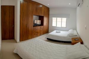 里韦拉Hotel Casa David的一间卧室配有一张床和一个木制橱柜