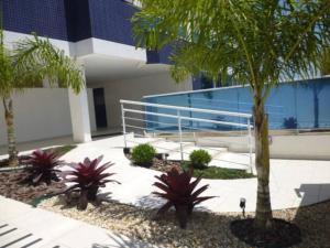 弗洛里亚诺波利斯Apartamento Safira / Praia dos ingleses的一座楼前种有棕榈树的庭院