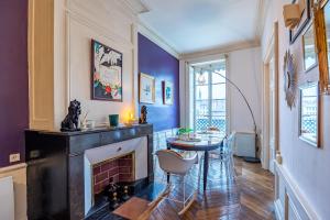 里昂Appartement Haussmannien d’Artiste, exception, quai de Saône balcon+Parking的客厅设有壁炉和桌子