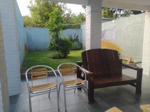 帕尔克德尔普拉塔Casas Arena y Sol - FRENTE AL MAR的庭院设有两把椅子和一张长凳