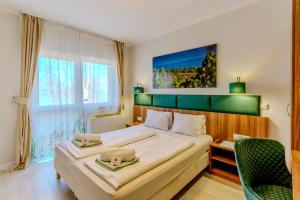 希欧福克Balaton Colors Beach Hotel的一间卧室配有一张大床和绿色床头板
