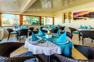 希欧福克Balaton Colors Beach Hotel的餐厅配有桌椅和蓝色餐巾