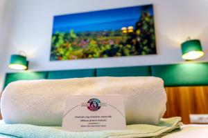 希欧福克Balaton Colors Beach Hotel的床上有标牌的一堆毛巾