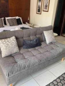 巴西利亚Belo Flat Resort Lake Side Beira Lago的客厅配有带枕头的灰色沙发