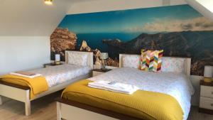 班克洛迪B&B and Cottage Rental "Mon Petit Cottage"的卧室配有两张床铺和山壁画
