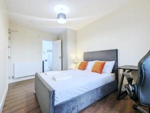 约克Rooms Near City Centre Private Bath Free Parking的一间卧室配有一张带橙色枕头的床和一张书桌