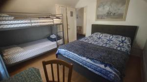圣路易斯-奥比斯保San Luis Obispo Hostel的一间卧室配有两张双层床和椅子