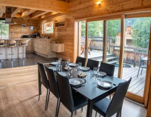 Le MélézetRésidence Pramouton - Chalets pour 9 Personnes 591的一间带桌椅的用餐室和一间厨房