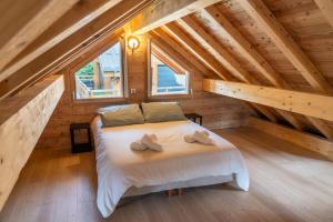 Le MélézetRésidence Pramouton - Chalets pour 9 Personnes 591的木制阁楼卧室配有一张床