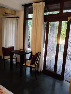马德拉潘帕斯Posada La Casona的一间带桌椅的用餐室和滑动玻璃门
