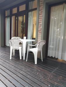 马德拉潘帕斯Posada La Casona的门廊上的一张白色桌子和两把椅子