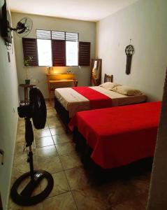 若昂佩索阿Espaço Jardim Secreto Hostel的酒店客房,配有两张带红色床单的床