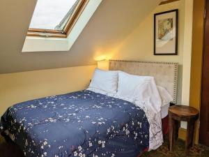 波特兰蓝鸟宾馆的一间卧室配有一张带蓝色毯子的床和窗户。