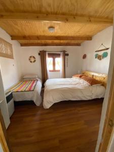 圣佩德罗·德·阿塔卡马Cabañas Voyage Atacama的一间卧室设有两张床和窗户。