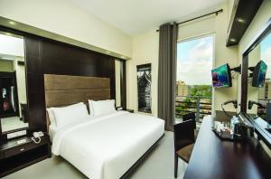 科伦坡科伦坡美景酒店的一间卧室配有一张床、一张书桌和一台电视
