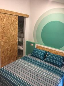 卡迪瓦2 bedrooms appartement with terrace and wifi at Xativa的一间卧室配有一张带蓝色枕头的床和绿色的墙壁