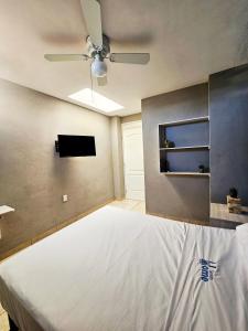 提瓦坎Sensity Home Recamara moderna的一间卧室配有一张床和吊扇