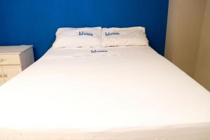 提瓦坎Sensity Home Recamara moderna的一张白色的床,上面有两个枕头