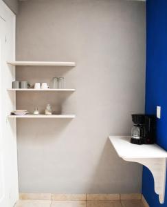提瓦坎Sensity Home Recamara moderna的厨房配有白色的架子和蓝色的墙壁