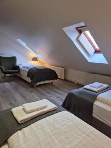 博尔加内斯哈芬纳尔福尔酒店的阁楼卧室配有两张床、椅子和天窗