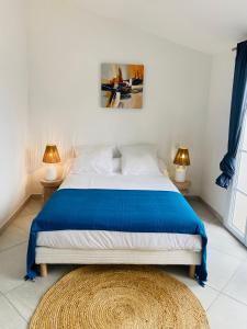 格里莫Maison de pêcheur的一间卧室配有一张床、两盏灯和地毯。