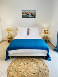 格里莫Maison de pêcheur的一间卧室配有一张带蓝色床罩和两盏灯的床。