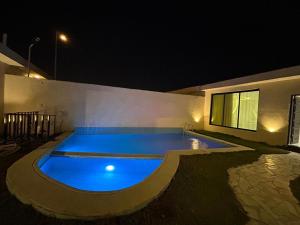 利雅德HAFAL Resort شاليهات هافال的夜间在房子里的一个游泳池