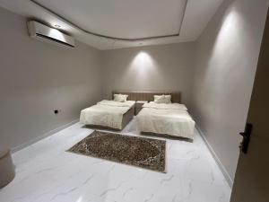 利雅德HAFAL Resort شاليهات هافال的白色墙壁客房的两张床