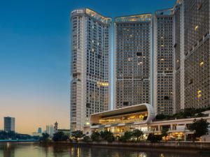 马尼拉Novotel Suites Manila at Acqua的两座高耸的摩天大楼,位于河边