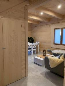 CzerwienneMountain View Chalet with HotTub and Sauna的客房设有木墙、沙发和桌子。