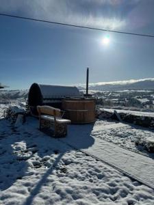 CzerwienneMountain View Chalet with HotTub and Sauna的坐在雪覆盖的山顶上的长凳
